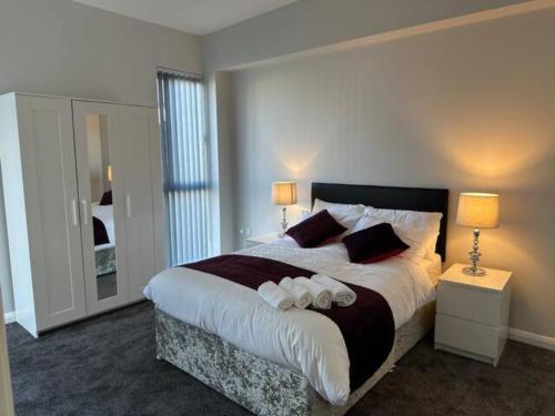 a bedroom with a large bed with two lamps and a mirror at Crystal Home in Manchester