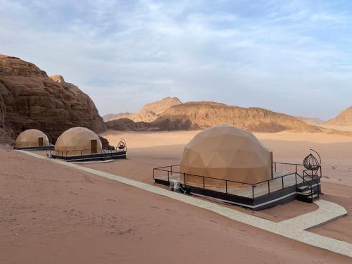 three domes in the desert near some rocks at Daniela Camp Wadi Rum in Wadi Rum