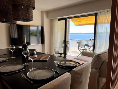 - une table à manger avec des verres à vin et une vue sur l'océan dans l'établissement Suite de luxe avec vue mer, à Sainte-Maxime