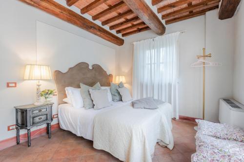 um quarto com uma grande cama branca e um sofá em Jacopo Farmhouse Apartment in Wine Resort in Lucca em Lucca
