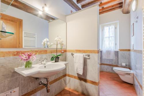 bagno con lavandino e servizi igienici di Jacopo Farmhouse Apartment in Wine Resort in Lucca a Lucca