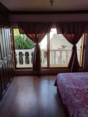 sypialnia z łóżkiem i dużym oknem w obiekcie casa de campo Angel w mieście Tehuacán