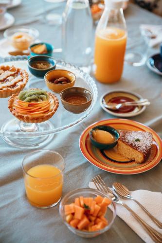a table with plates of food and glasses of orange juice at LUCCICAMARE family-run BeB in Noto