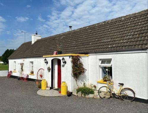 a white house with a bike parked in front of it at Toddys Hideaway in Cavan