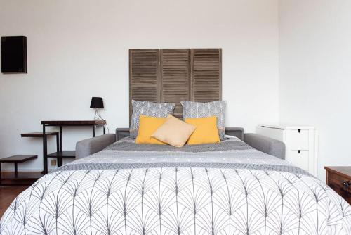 ein Schlafzimmer mit einem großen Bett mit gelben Kissen in der Unterkunft Studio Gare Saint Jean in Bordeaux