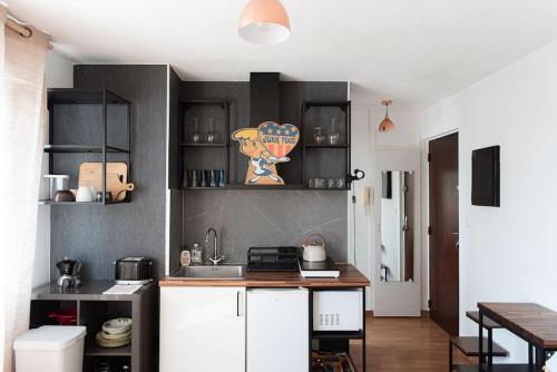 eine Küche mit schwarzen und weißen Schränken und einem Tisch in der Unterkunft Studio Gare Saint Jean in Bordeaux