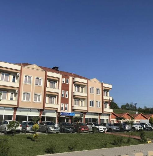 a parking lot with cars parked in front of a building at Boğaz 