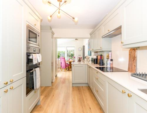 a kitchen with white cabinets and a wooden floor at Fashionable Chic Townhouse in D4 in Dublin
