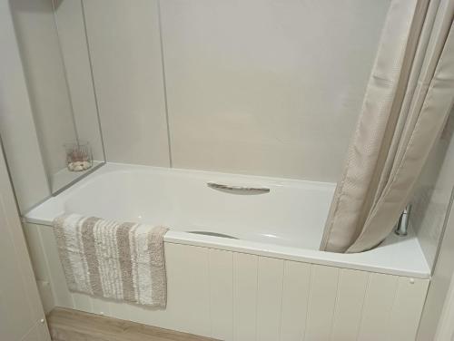 La salle de bains blanche est pourvue d'une douche et d'une serviette. dans l'établissement Barchester House Apartment Standard, à Salisbury