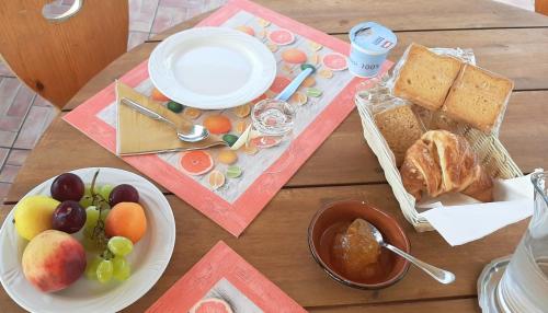 a wooden table with a plate of fruit and bread at Casale Battaglini in Castelnuovo Cilento