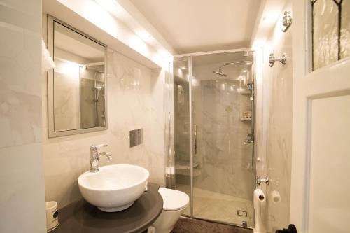 een witte badkamer met een wastafel en een douche bij Grandma's House in Kalymnos