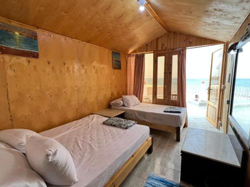 Duas camas num quarto com vista para o oceano em Panorama Lodge Nuweiba em Nuweiba