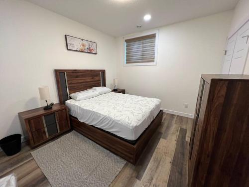 a bedroom with a bed and a night stand at Modern Suite by Spruce Meadows in Calgary
