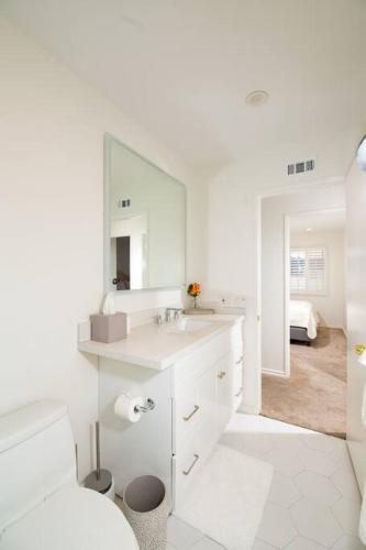 a white bathroom with a sink and a mirror at Brand New Remodeled 3 Bedroom Home in Reseda in Los Angeles