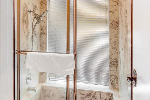 La salle de bains est pourvue d'une douche et d'une serviette sur une porte de douche en verre. dans l'établissement Tranquil Pines Estate, à Shaver Lake
