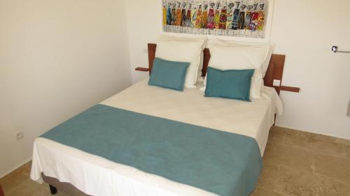 a bedroom with a bed with two blue pillows at Ocean Roof in Santa Maria