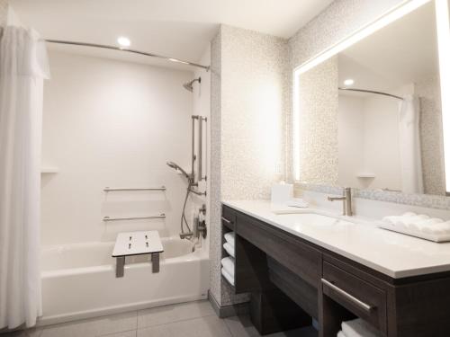 a white bathroom with a tub and a sink and a shower at Home2 Suites By Hilton Santa Rosa Beach in Santa Rosa Beach