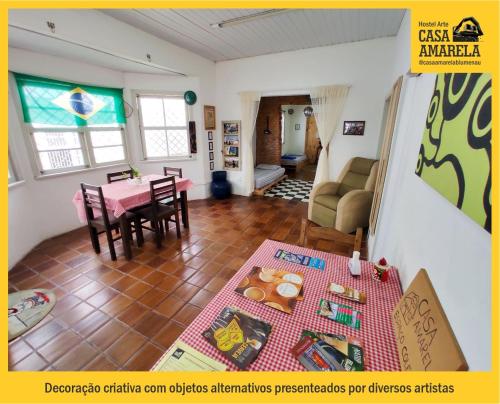 a living room with a table and a dining room at Casa Amarela Blumenau Hospedagem Alternativa in Blumenau