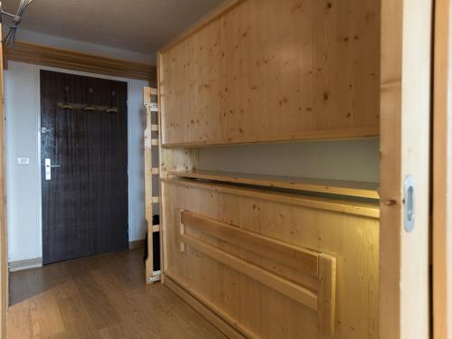 Cette chambre comprend un placard avec des murs en bois et une porte. dans l'établissement Studio de Luxe à 500m des Pistes, Balcon, Wi-Fi, Animaux Acceptés - FR-1-449-47, à Tignes
