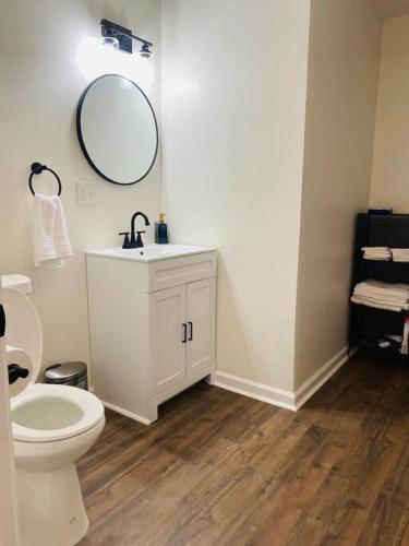a bathroom with a white toilet and a mirror at The Grayson Home 3 bedroom 1 bath in New Albany