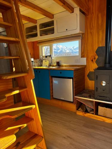 cocina con armarios azules y fogones en Namakai.tinyhouse, minimalism in a magic place en Los Árboles