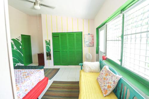 a balcony with green doors and two couches at La Casa de Vida Natural in Rio Grande