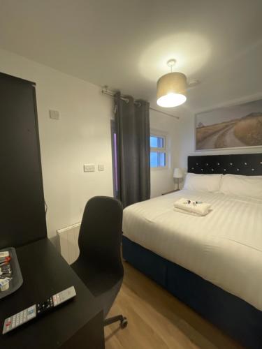 a bedroom with a bed and a desk and a chair at Blackheath Stay in London