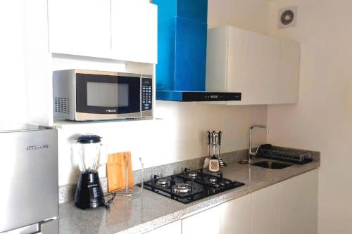 a kitchen with a stove and a microwave at (T) Exclusivo departamento en Piura in Piura