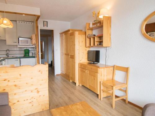 Il comprend une cuisine et un salon avec une table et une télévision. dans l'établissement Studio 27m², Sud/Ouest, à 500m des pistes, Wifi, Animaux admis - FR-1-449-153, à Tignes