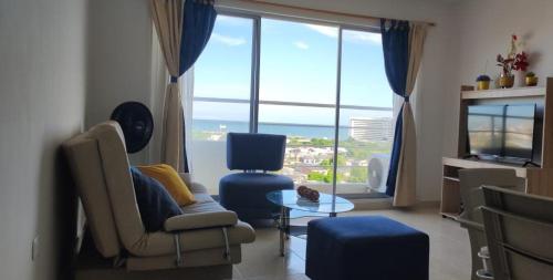 uma sala de estar com um sofá e cadeiras e uma grande janela em apartamento1108 em Cartagena das Índias