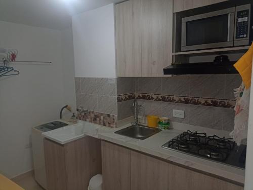 uma pequena cozinha com um lavatório e um micro-ondas em apartamento1108 em Cartagena das Índias