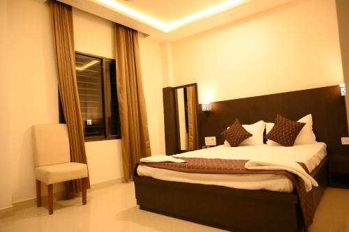 BishnāthHotel Tripti-Biswanath Chariali的一间卧室，里面有一张床、一把椅子和一扇窗户