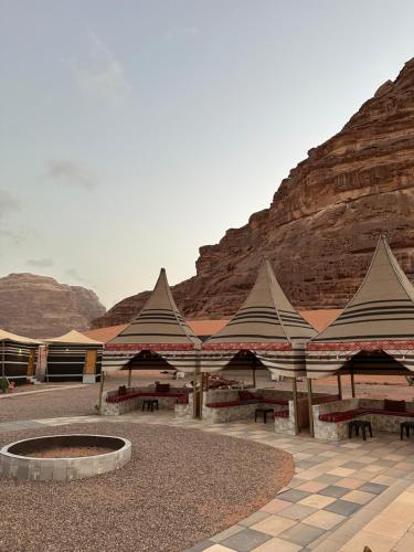a building with a fire pit in front of a mountain at Sunset Gem _ Wadi Rum in Disah