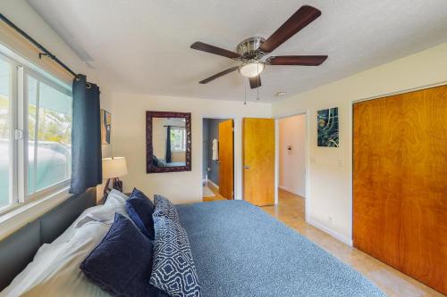 a bedroom with a bed with a ceiling fan at Hale Kai in Keaau