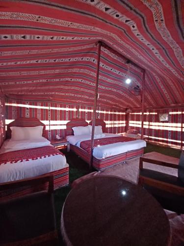 a room with two beds and a table in it at Sunrise Desert Local Private Camp in Bidiyah