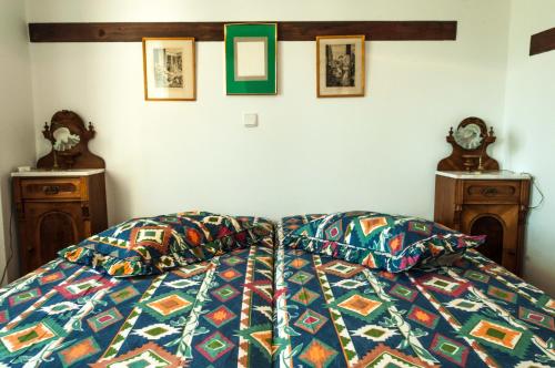 a bed with a colorful comforter and two night stands at Pontinos Villa in Myloi