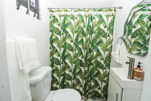 a bathroom with a green banana shower curtain at La Casa de Vida Natural in Rio Grande