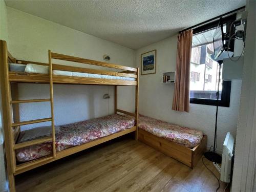 deux lits superposés dans une chambre avec fenêtre dans l'établissement Studio cosy 4 pers avec balcon sud, skis aux pieds à Reberty 1850 - FR-1-452-44, aux Menuires