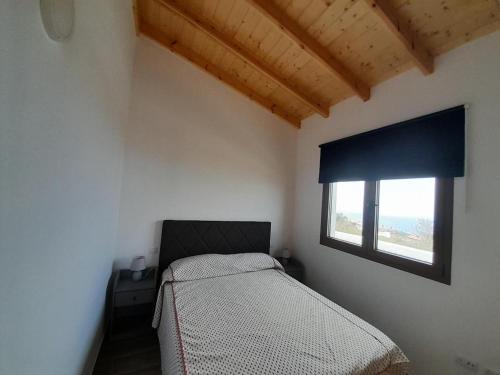 a small bedroom with a bed and a window at Villa La Casita. in La Matanza de Acentejo