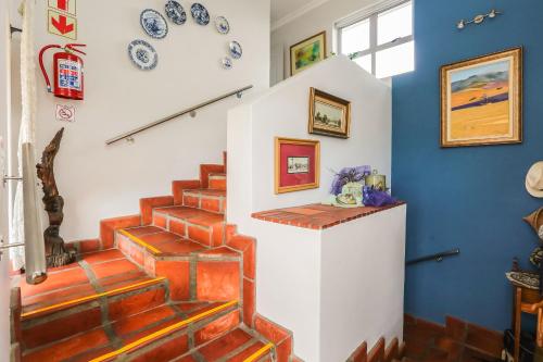 a staircase in a house with plates on the wall at Imberbe in Struisbaai