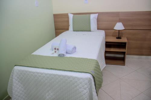a bedroom with a bed with two towels on it at Domus Hotel Palmeiras - Canaã dos Carajás in Canaã dos Carajás
