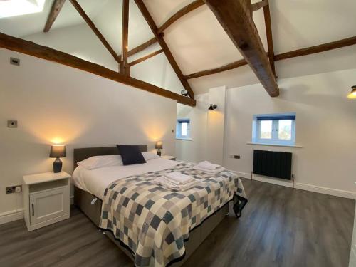 a bedroom with a large bed in a room with wooden floors at Spacious 4 bedroom, 4 bathroom barn conversion home with private garden and free parking in Burn