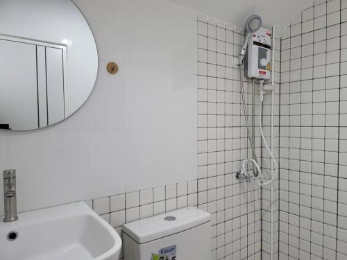 a bathroom with a mirror and a toilet and a sink at Minimal homey near Ruam Chok mall 15 min to city. in Chiang Mai