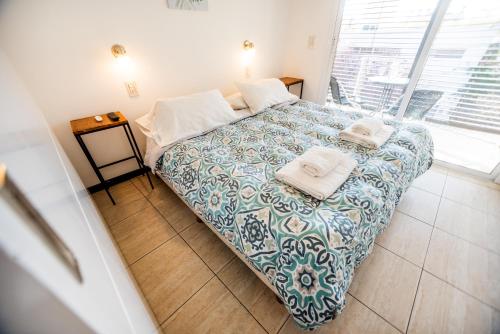 1 dormitorio con 1 cama con toallas en Candelaria Apartment en Mendoza