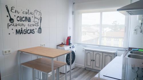 une cuisine avec une table et une fenêtre. dans l'établissement PISO AVILES CENTRO PARQUE FERRERA, à Avilés