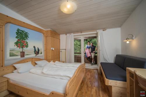 サン・ジョヴァンニ・イン・ヴァッレ・アウリーナにあるAktiv-Hotel Steinpentのベッドルーム1室(ベッド1台、ソファ、窓付)