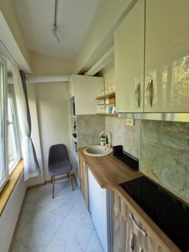 uma pequena cozinha com um lavatório e uma cadeira em Malavi TN1 top center studio Ruse em Ruse