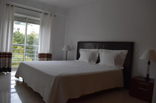 1 dormitorio con 1 cama con sábanas blancas y ventana en The Best Downtown Albufeira, en Albufeira