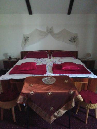 a bedroom with a large bed with red pillows at Apartments Bakine Čarolije in Karanac