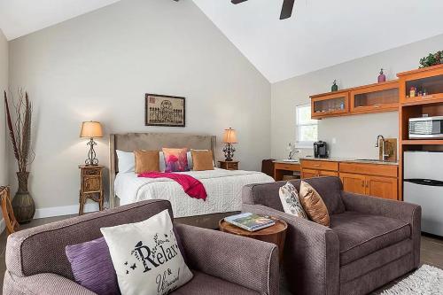 a bedroom with a bed and a couch and a chair at Luxury Cottage with Views-Fireplace-Spa Bath in Fredericksburg